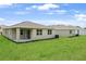 Exterior home view showcasing a well-maintained lawn and backyard patio at 1131 Olivine Ave, Dundee, FL 33838