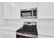 Close-up of stainless steel appliances and sleek countertops, complemented by stylish white cabinetry at 1131 Olivine Ave, Dundee, FL 33838