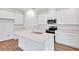 Modern kitchen featuring white cabinets, stainless steel appliances, and a center island with a sink at 1131 Olivine Ave, Dundee, FL 33838
