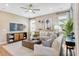 Inviting living room with ceiling fan, plush seating, and a modern decorative fireplace at 1131 Olivine Ave, Dundee, FL 33838