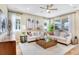 Cozy living room with large windows, ceiling fan, comfortable seating, and stylish decor at 1131 Olivine Ave, Dundee, FL 33838