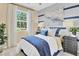 Inviting bedroom featuring navy and white bedding, striped accent wall, and a bright window at 1135 Olivine Ave, Dundee, FL 33838