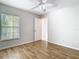 Neutral bedroom features wood floors, ceiling fan, window, and door at 12622 Earnest Ave, Orlando, FL 32837