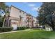 Low angle shows the condominium building and well-maintained green spaces, and tropical trees at 1357 Venezia Ct # 302, Davenport, FL 33896