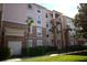 Beautiful condo building featuring stucco siding, palm trees and a private balcony on multiple floors at 1357 Venezia Ct # 302, Davenport, FL 33896