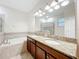 Bathroom featuring double sinks with granite counters, a separate shower, and a soaking tub at 15147 Driftwood Bend St, Winter Garden, FL 34787