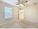 Comfortable bedroom with neutral carpet, window view and a ceiling fan at 15147 Driftwood Bend St, Winter Garden, FL 34787