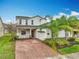 Charming two-story home with brick driveway, attached garage, and a well-manicured lawn with lush landscaping at 15147 Driftwood Bend St, Winter Garden, FL 34787