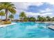 Expansive community pool surrounded by palm trees and lounge chairs at 1873 Flora Pass Pl, Kissimmee, FL 34747