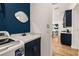 Laundry room with washer and sink, accentuated by navy blue accent wall at 1873 Flora Pass Pl, Kissimmee, FL 34747