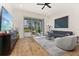 Bright living room with a modern design, featuring stylish furniture, hardwood floors, and a sliding glass door to the patio at 1873 Flora Pass Pl, Kissimmee, FL 34747