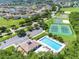 Aerial view of a community featuring a pool, tennis and basketball courts, parking and residential homes in the background at 214 Farrington Ln, Kissimmee, FL 34744