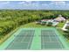 Aerial view of community tennis courts and pool featuring lush landscaping, and an amenity center at 214 Farrington Ln, Kissimmee, FL 34744