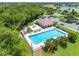 Aerial view of community pool, splash pad, clubhouse and parking surrounded by green trees, well maintained and manicured grounds at 214 Farrington Ln, Kissimmee, FL 34744