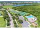 Wide aerial view of community amenities, including a pool, tennis courts, a basketball court, and a beautiful lake at 214 Farrington Ln, Kissimmee, FL 34744