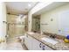 Elegant bathroom featuring double sinks, a glass shower, and stylish tile flooring at 214 Farrington Ln, Kissimmee, FL 34744