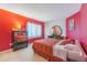 Cozy bedroom with bright red accent wall, comfortable bed, and natural light at 214 Farrington Ln, Kissimmee, FL 34744