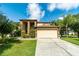 Charming two-story home featuring a well-manicured lawn, complemented by lush landscaping and a two-car garage at 214 Farrington Ln, Kissimmee, FL 34744