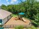 Community playground featuring a play structure with slide and climbing area, surrounded by a safety mulch surface and fencing at 214 Farrington Ln, Kissimmee, FL 34744