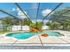 Enclosed pool area features a waterfall feature, poolside seating, and a paved deck under a screened enclosure at 214 Farrington Ln, Kissimmee, FL 34744