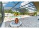 Enclosed pool area features a waterfall feature, poolside seating, and a paved deck under a screened enclosure at 214 Farrington Ln, Kissimmee, FL 34744