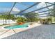 Enclosed pool area features a waterfall feature, poolside seating, and a paved deck under a screened enclosure at 214 Farrington Ln, Kissimmee, FL 34744