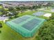 Aerial view of community tennis courts and basketball court amidst a backdrop of residential homes in a well-maintained neighborhood at 214 Farrington Ln, Kissimmee, FL 34744