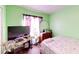 Bedroom with a TV and a floral bedspread with a desk and round mirror in the background at 2416 Oak Mill Dr, Kissimmee, FL 34744