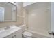 Well-lit bathroom featuring a vanity, toilet, and bathtub with white tile surround at 2416 Swailes Dr # 8, Orlando, FL 32837