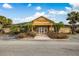 Community clubhouse featuring a classic yellow facade, palm trees, and a welcoming entrance at 2416 Swailes Dr # 8, Orlando, FL 32837