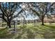 Outdoor exercise equipment with pond views nestled under mature trees in a well-maintained community at 2416 Swailes Dr # 8, Orlando, FL 32837