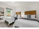 Bedroom featuring two beds, white bedding and grey throws, and a window at 2634 Corvette Ln, Kissimmee, FL 34746