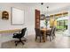 Dining area with stylish pendant lighting, adjacent to a functional workspace and sliding doors to the backyard at 2634 Corvette Ln, Kissimmee, FL 34746
