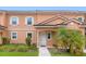 Charming two-story townhouse featuring a red tile roof and a well-maintained landscaped front yard at 2634 Corvette Ln, Kissimmee, FL 34746