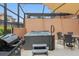 Outdoor patio space featuring a hot tub, grill, and dining area under a covered enclosure at 2634 Corvette Ln, Kissimmee, FL 34746