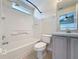 A white tiled bathroom with a shower-tub combo and a sink at 2993 Kokomo Loop, Haines City, FL 33844