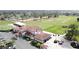 Aerial view of the clubhouse, with a beautiful tile roof, golf course, and surrounding landscaping at 2993 Kokomo Loop, Haines City, FL 33844