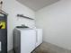 Bright laundry area features a washer, dryer, water heater and shelving unit at 2993 Kokomo Loop, Haines City, FL 33844