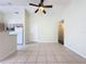 Open-concept living space featuring tile floors, a ceiling fan, and a view into the kitchen at 2993 Kokomo Loop, Haines City, FL 33844