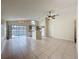 Living room showcasing tile flooring, ceiling fan, and views of kitchen and the pool at 2993 Kokomo Loop, Haines City, FL 33844