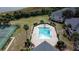 Aerial view of the community pool and tennis courts, surrounded by lush landscaping and nearby buildings at 2993 Kokomo Loop, Haines City, FL 33844