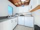 A well-lit laundry room featuring a sink, washer, dryer, and storage cabinets at 3004 Lake Margaret Dr, Orlando, FL 32806