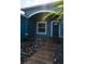 A home's welcoming front entrance with tiled pathway, decorative rock, and a stylish blue door at 318 Elderberry Ct, Kissimmee, FL 34759