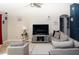 Cozy living room with tiled flooring, a ceiling fan, a comfortable sofa and chair with decorative pillows at 318 Elderberry Ct, Kissimmee, FL 34759