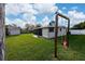 Wide-angle of the backyard with a covered porch and swing set at 403 Poinciana Cir, Kissimmee, FL 34744