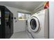 Functional laundry room features washer, dryer, refrigerator, and storage shelving at 403 Poinciana Cir, Kissimmee, FL 34744