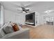 Modern living room featuring hardwood floors, a stylish sectional, and a sleek entertainment center at 403 Poinciana Cir, Kissimmee, FL 34744