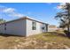 Backyard of a gray house with a sliding glass door and an AC unit at 408 Danube Dr, Poinciana, FL 34759