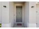 Inviting entryway with a gray front door, decorative welcome mat, and modern outdoor lighting at 408 Danube Dr, Poinciana, FL 34759