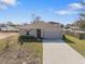 Front exterior of a house with a gray garage door and gray trim at 408 Danube Dr, Poinciana, FL 34759